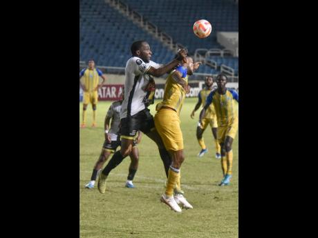 Clifford Thomas (left) of Moca and Andre Fagan of Harbour View battle for the ball during their Concacaf Caribbean Cup first leg third place playoff  match at Sabina Park last night.