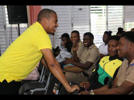 Minister of Agriculture, Fisheries and Mining, Floyd Green (left), interacts with youngsters during the national ‘Eat Jamaica Day’ ceremony at the College of Agriculture, Science and Education in Portland recently.
