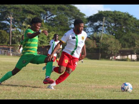 Vere’s Alrick Maitland (left) hounds Humble Lion’s Javain Thompson for possession during their Jamaica Premier League encounter at the Wembley Centre of Excellence yesterday. Vere won 2-1.