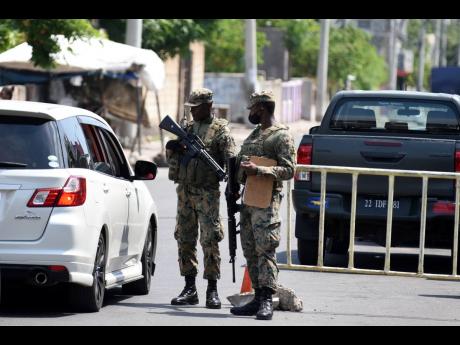 Members of the security forces at a zone of special operation checkpoint in Greenwich Town, St Andrew. 