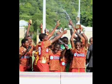 Wolmer’s Boys’ School Under-14 schoolboy footballers celebrate winning the ISSA Burger King competition at Stadium East Field yesterday. Wolmer’s defeated Excelsior 1-0 to lift the title.