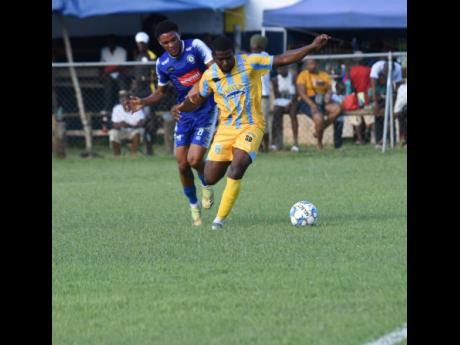 Waterhouse FC’s Keithy Simpson (right) shields the ball from Mount Pleasant FC’s Odane Murray (left) during their Wray and Nephew/Jamaica Premier League match at the Drax Hall Sports Complex in St Ann recently.