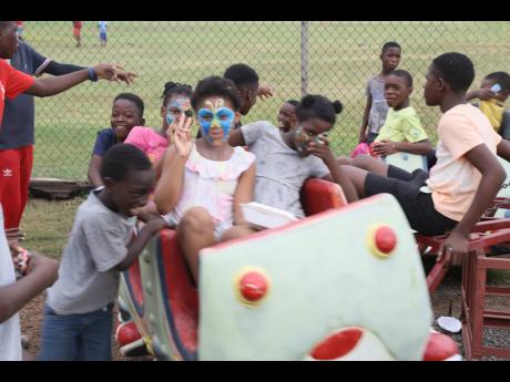 Children from Boys’ Town enjoy a ride during the Christmas treat, held on Sunday at the Collie Smith Drive Sporting Complex in the South St Andrew community. 