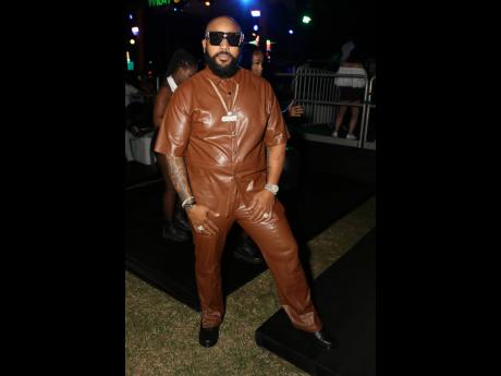 Record producer Striker Lee serves a suave look in this brown leather Versace set.