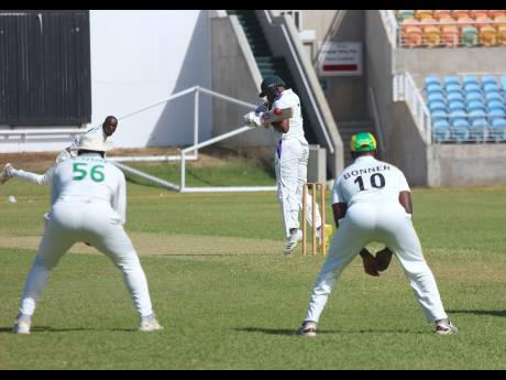 Credit: Lennox Aldred Fast bowler Gordon Bryan (left) beats the edge of the bat of opener Javaughn Buchanan (second right) during the first Jamaica Scorpions trial match at Sabina Park recently. Bryan’s teammates Nmrumah Bonner (right) and Leroy Lugg watch the action.