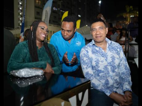 Prime Minister Andrew Holness (right) and wife Juliet listen keenly to General Manager of the Urban Development Corporation Bobby Honeyghan.