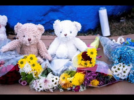 Bears and flowers sit in front of a rock painted to memorialise Perry High School shooting victim Ahmir Jolliff at the school on Saturday in Perry, Iowa. Jolliff was one of eight victims in the shooting. Seven others received wounds or injuries of varying degrees, the Iowa Department of Public Safety said.