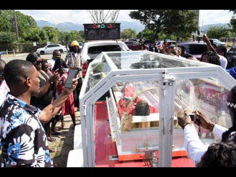 Credit: Ian Allen Relatives and friends try to get one last glimpse of Gully Bop.
