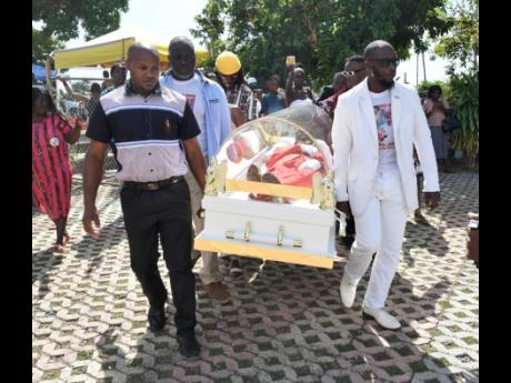 Pallbearers carry Gully Bop’s body before the thanksgiving service.