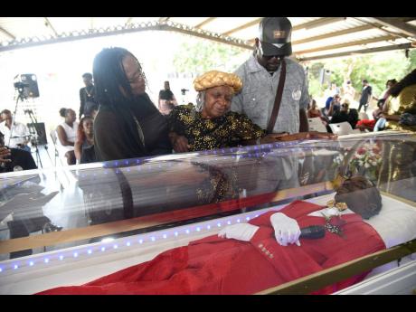 Norma Blake (centre), mother of Gully Bop, breaks down in tears while viewing his body. Lending support are her children Francine and Andrew.