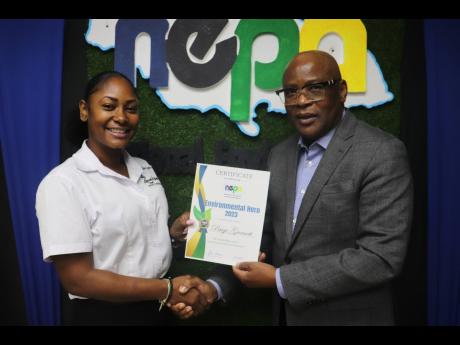Paige Garnett (left), winner of the the National Environment and Planning Agency’s Environmental Hero Competition, accepts a certificate of recognition from the agency’s CEO Peter Knight.