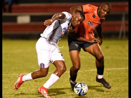 Cavalier’s Orlando Russell (left) and Tivoli Gardens’ Richard Brown fight for possession during their Jamaica Premier League match at Anthony Spaulding Sports Complex yesterday. The game drew 0-0.