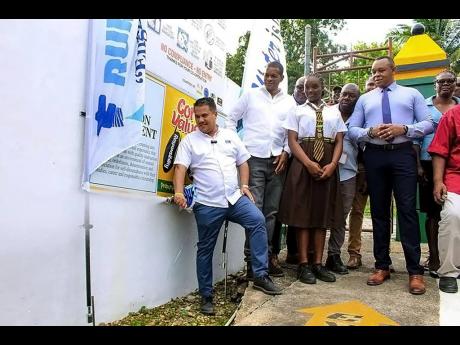 Credit: Contributed Minister with responsibility for water, Matthew Samuda (left), turns on a pipe, which is connected to the newly commissioned Cascade water supply in Hanover Eastern.