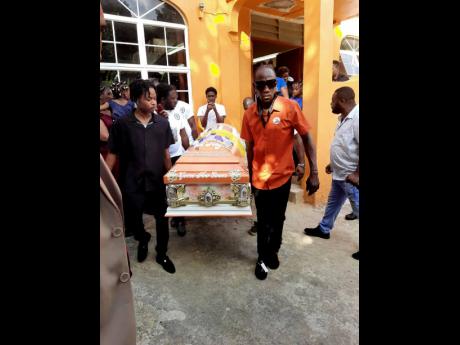 Pallbearers carry the coffin bearing the remains of Louie Fagan from the New Testament Church of God in Sherwood Content, Trelawny on Saturday.