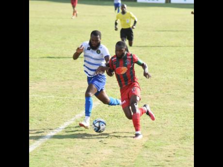 Vere United FC’s Matt Ludford (left) and Montego Bay United FC’s (MBU) Owayne Gordon battle for possession of the ball during their Wray and Nephew-sponsored Jamaica Premier League match at the Wespow Park in Montego Bay yesterday. Montego Bay won 2-0.