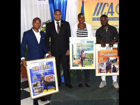 Ieasha Johnson (second right), shares poses for a photo with agriculture minister Floyd Green (second left), and fellow young farmers Kacheif Brown (left), and Junior Senior.