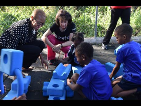 Minister of Education and Youth, Fayval Williams (left), and UNICEF Jamaica Country Representative, Olga Isaza (second left), interact with students at the McCam Child Care and Development Centre in Kingston, in observance of Global School Play Day on Wednesday.