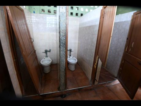 Broken toilet doors and missing seats in a section of the Papine Market.