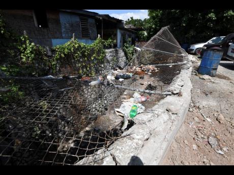 A broken-down section of the perimeter fencing at the Cross Roads Market.
