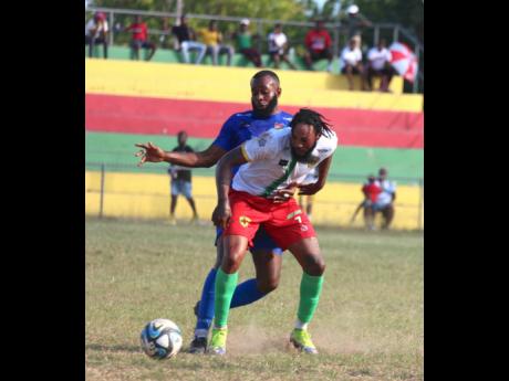Humble Lion’s Roshane Sharpe (right) shields the ball from the Dunbeholden’s Fabian McCarthy during their Jamaica Premier League encounter at Effortville Community Centre in Clarendon on January 21, 2024