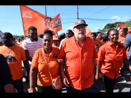 Mark Golding is flanked by PNP councillor candidates Louise Newland (left) and Sarah Marshall in his constituency of St Andrew South.