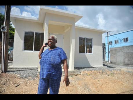 Credit: File Marlene Bennett stands in front of a two-bedroom unit at Tower Street, Kingston. The house was conducted under the New Social Housing Programme.