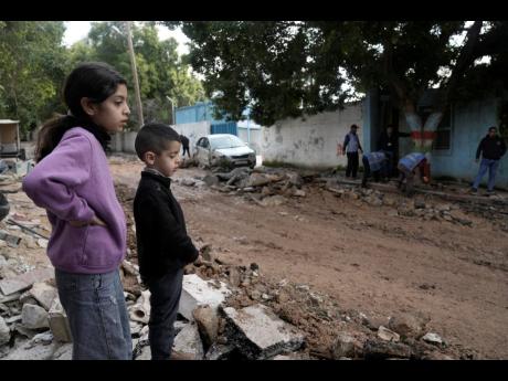 Credit: AP Children look at the site where three Palestinians were killed by Israeli fire in Faraa refugee camp.