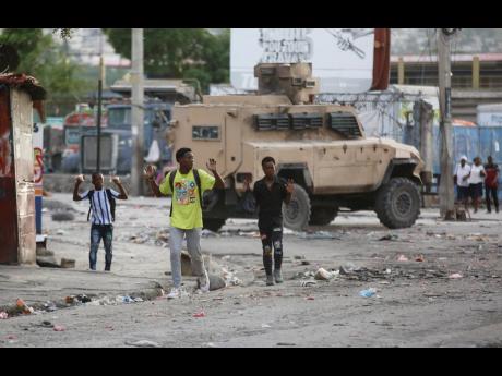 Youths raise their hands to show police they are not carrying weapons during an anti-gang operation at the Portail neighbourhood in Port-au-Prince, Haiti.