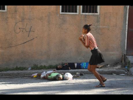A woman walks past bodies of two men killed by unknown assailants in Port-au-Prince, Haiti, on Sunday.