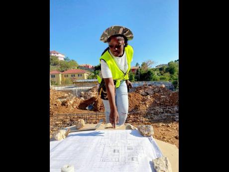 Credit: Contributed Facey studies the blueprints of a structure.