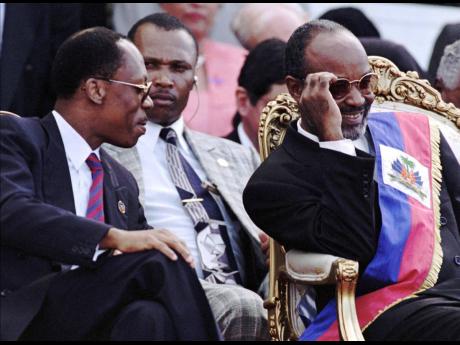 Former Haitian President Jean-Bertrand Aristide (left) jokes with newly sworn-in Haitian President Rene Preval during inauguration ceremonies at the National Palace in Port-au-Prince, Haiti, in 1996. 
