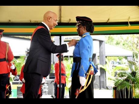 Sheelyn Manya receives the Badge of Honour for Meritorious Service from Governor General Sir Patrick Allen.