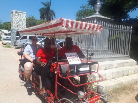 Paul Reid (right) with two guests and a co-worker on his pedicab.