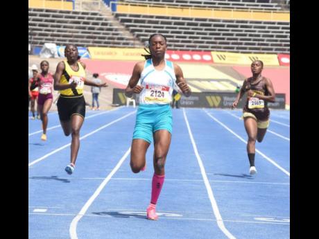 Lacovia High School's Sabrina Dockery (centre) goes for a jog to win her girls' Class 2 200-metre heat at the ISSA/GraceKennedy Boys and Girls' Athletics Championships inside the National Stadium this morning.