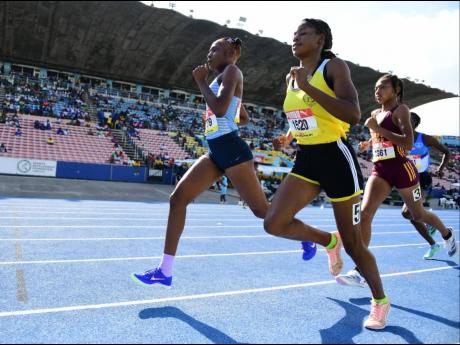 Credit: Gladstone Taylor Edwin Allen High's Rickeisha Simms (left) takes the lead in the Class One girls' 800 metres semi-final one at the ISSA/GraceKennedy Boys and Girls' Athletics Championships today at the National Stadium. Simms won in 2:16.18 minutes.