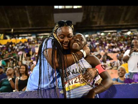 Credit: Gladstone Taylor Edwin Allen's Tonyan Beckford (right) gets a hug from her mother Deneka Smith after she won the Open girls' 400 metres hurdles at the ISSA/GraceKennedy Boys and Girls' Athletics Championships at the National Stadium tonight. Beckford ran 56.70 to secure the victory.
