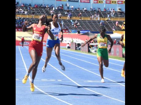 Natrece  East (left) of Wolmer's Girls' School eases after securing victory over her rivals in the Class Three girls' 200 metres at the ISSA/GraceKennedy Boys and Girls' Athletics Championships at the National Stadium today. East clocked 24.29 seconds for the victory.