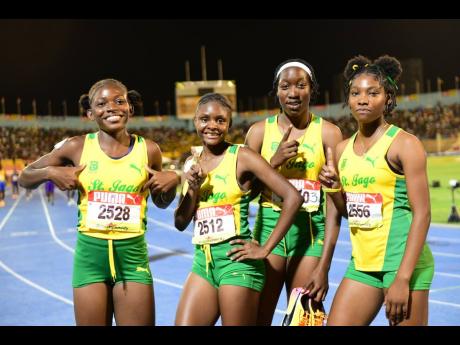 St. Jago HIgh's Open girls' sprint medley members celebrate their victory at the ISSA/GraceKennedy Boys and Girls' Athletics Championships at the National Stadium tonight.