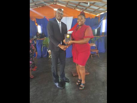  Pastor Sean Williams presents teacher Sadera Francis with her award. 