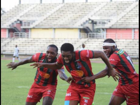 Montego Bay United’s Daniel Reid (centre) celebrates with his teammates Brian Brown (left) and Jourdain Fletcher after scoring their second goal.