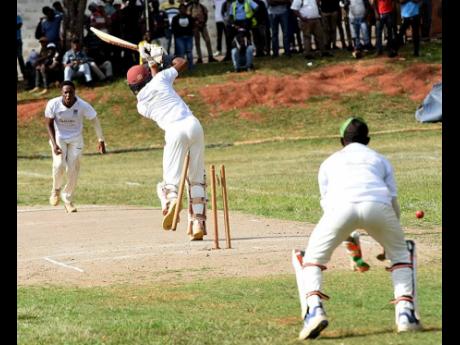 May Day High's Javed Williams (centre) had his stumps flying from a delivery from Manchester High's Rhevon Morgan (left) on the first day of the ISSA/GK Insurance Headley Cup final at Manchester on Wednesday. Wicketkeeper Pajay Nelson helps Morgan celebrate the wicket.