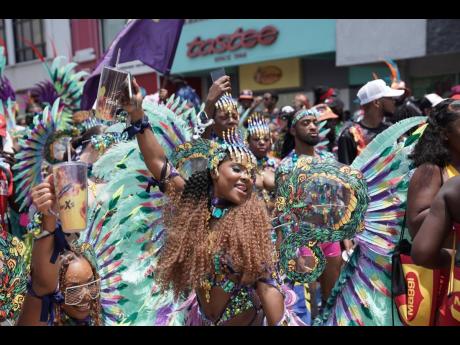 Nyoka Manning dazzles in her vibrant GenXS costume, adorned with a captivating blend of light blue, purple, yellow and shades of green.