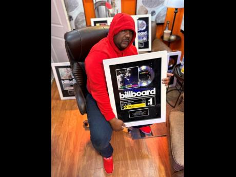 Producer Kemar McGregor holds one of his Billboard plaques.