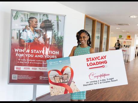 Simeca Alexander-Williamson poses with a symbolic voucher of her Luxury Staycation win courtesy of Digicel.