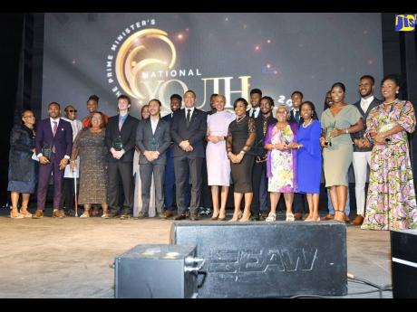 Prime Minister Andrew Holness (sixth left), and Minister of Education and Youth Fayval Williams (sixth right), are flanked by recipients of the Prime Minister Youth Award for Excellence 2022, at the awards ceremony held at Jamaica House.