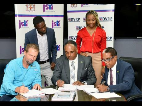 Dr Norman Dunn (seated, right), the state minister in the Ministry Labour and Social Security; Omar Sweeney (seated at centre) managing director, Jamaica Social Investment Fund; and Anthony Sampson (seated, left), operations director, S&G Road Surfacing Materials Limited, participating in the signing of the $197-million contract for the Annotto Bay Coastal Protection Beach Nourishment Project.


