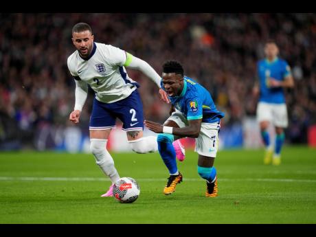 Brazil’s Vincius Junior (right)  is tackled by England’s Kyle Walker during an international friendly match between England and Brazil, at Wembley Stadium in London, Saturday, March 23, 2024. 
