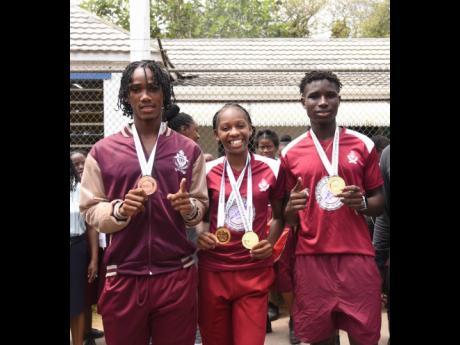 Muschett High’s double gold medallist Shanoya Douglas (centre) celebrates with gold medal winner Johan-Ramaldo Smythe (right) and bronze medal winner Osmond Holt during the recent parade to honour them by the school in Wakefield, Trelawny, after their success at the ISSA/GraceKennedy Boys and Girls’ Athletics Championships in March.
