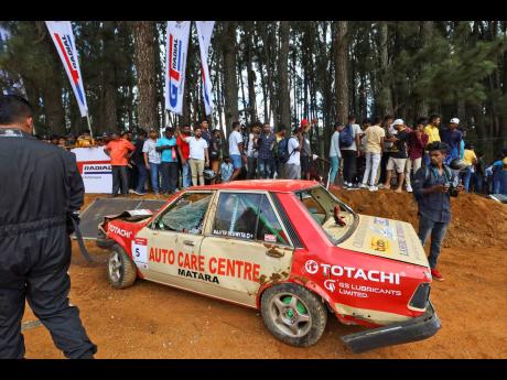 People gather around a car that had crashed into the spectators during the Fox Hill Supercross, a motor racing event organised by the Sri Lanka’s army, in Diyatalawa, Sri Lanka, yesterday.