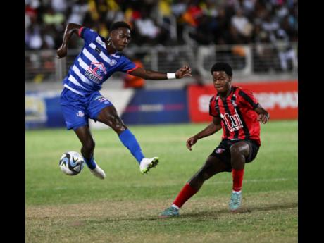 Portmore United’s Okelo Howard heels the ball away from Arnett Gardens’ Shadiko Wizzard during their Jamaica Premier League quarter-final 1-1 draw at Sabina Park yesterday.